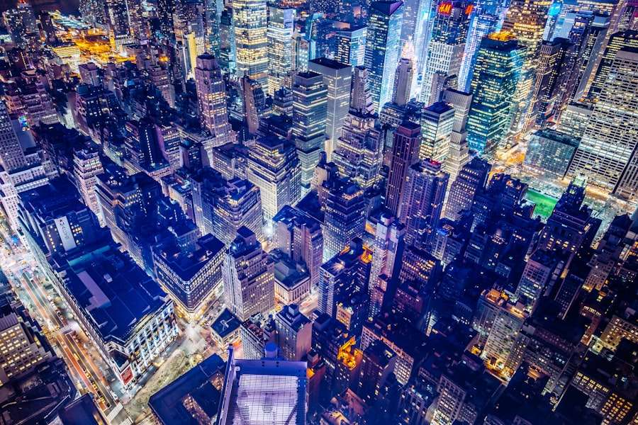 SEO Hannover - Luftaufnahme einer lebendigen Stadtlandschaft bei Nacht mit zahlreichen beleuchteten Wolkenkratzern und Gebäuden. Die Straßen sind mit Straßenlaternen und Autoscheinwerfern beleuchtet, wodurch ein gitterartiges Muster entsteht. Die Szene ist voller städtischem Leben und Energie. Local SEO Agentur Hannover.