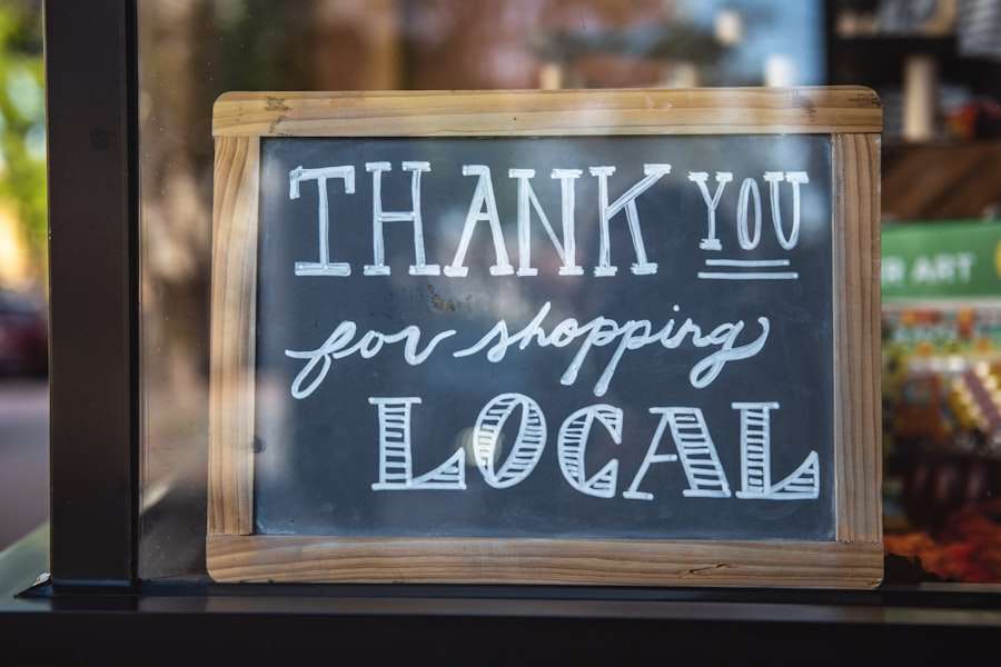 Suchmaschinenoptimierung Hannover - Auf einem Schild mit Holzrahmen steht in weißer, handschriftlicher Schrift auf Tafelhintergrund „Danke, dass Sie lokal einkaufen“. Das Schild hängt in einem Schaufenster. Local SEO Agentur Hannover.