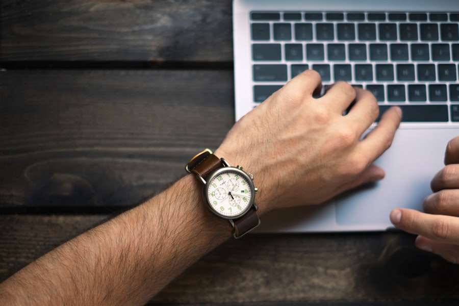 Suchmaschinenoptimierung Hannover - Die linke Hand einer Person, die eine Armbanduhr mit braunem Lederarmband trägt, liegt auf der Tastatur eines Laptops. Die rechte Hand ist teilweise sichtbar und zeigt auf den Laptop-Bildschirm, auf dem das Ranking bei Google angezeigt wird. Der Laptop liegt auf einer dunklen Holzoberfläche. Local SEO Agentur Hannover.