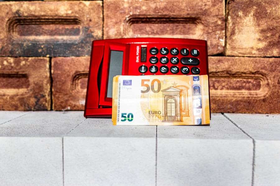 SEO Hannover - Ein roter digitaler Taschenrechner liegt auf einem Stapel Ziegelsteine. Davor liegt auf einer Betonfläche ein 50-Euro-Schein, der vielleicht über die Kosten für die Website-Erstellung nachdenkt. Local SEO Agentur Hannover.