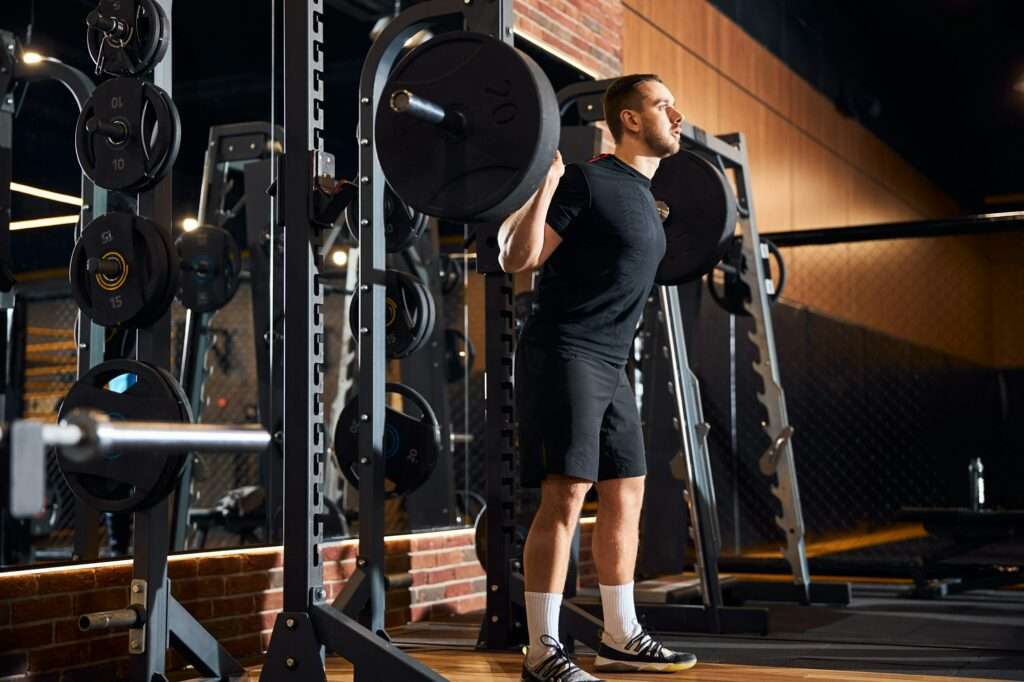 Focused brunette man working hard at local gym