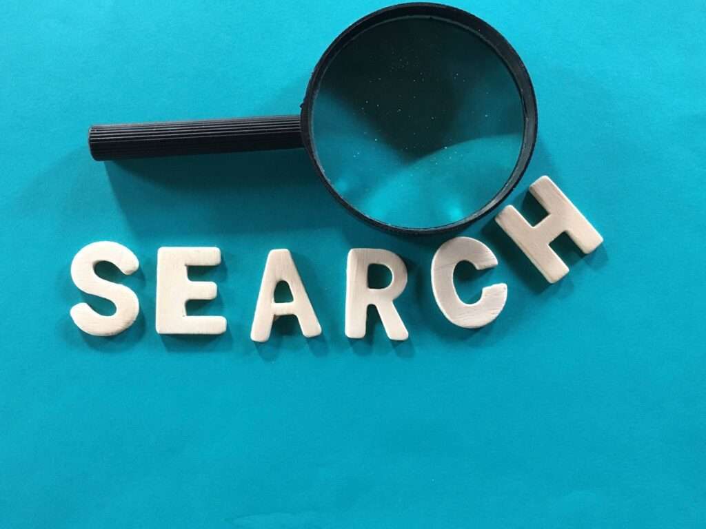 Webdesign Hannover - Eine Lupe ruht auf weißen, dreidimensionalen Buchstaben, die auf blauem Hintergrund „SEARCH“ (Suchen) buchstabieren, und wirft die Frage auf: Was versteht man unter semantischer Suche?. Local SEO Agentur Hannover.