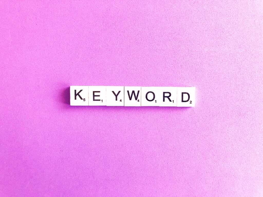 Webdesign Hannover - Scrabble-Steine mit dem Satz „Sind Keywords noch wichtig?“ sind in einer geraden Linie auf einem leuchtend violetten Hintergrund angeordnet. Local SEO Agentur Hannover.
