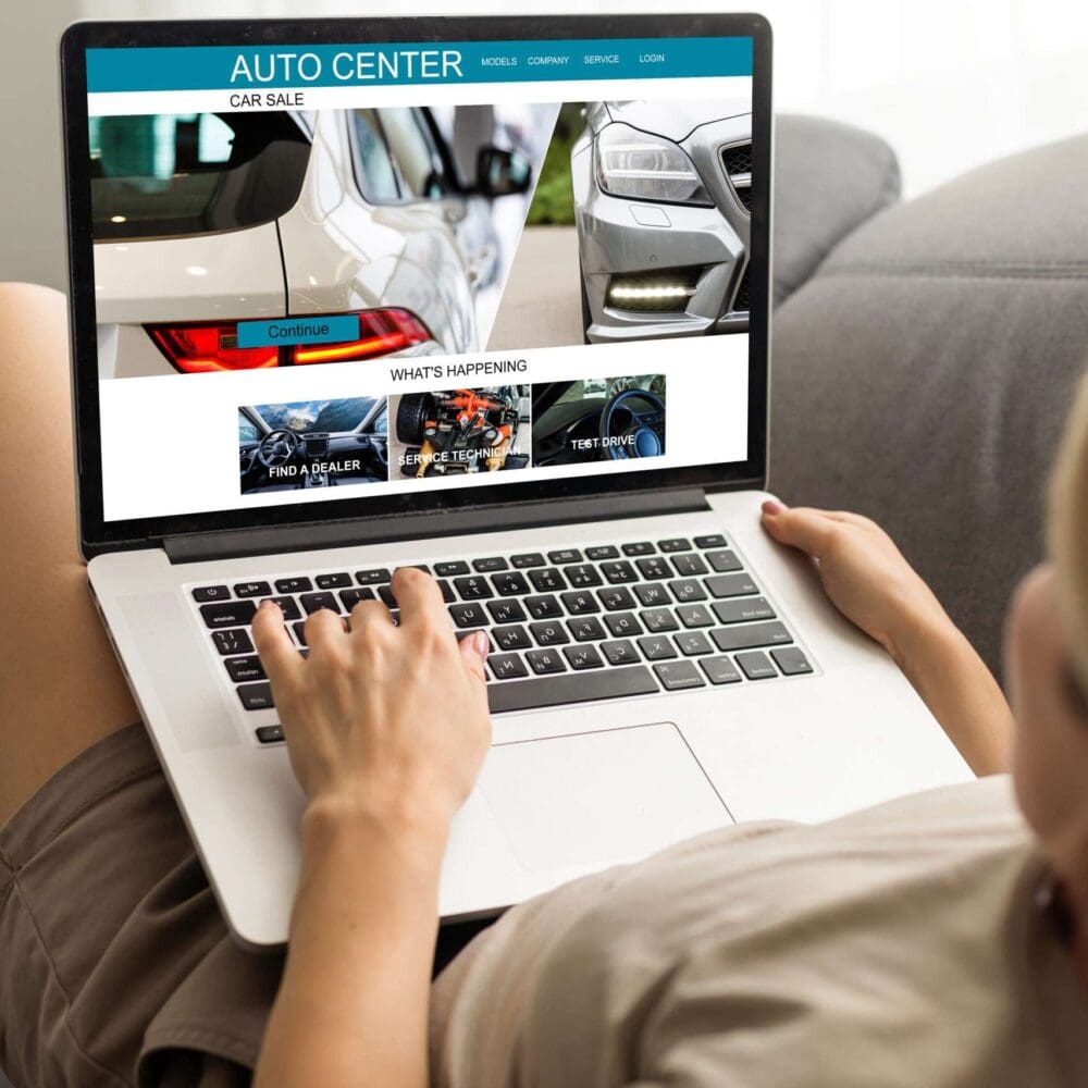 Webdesign Hannover - Eine Person sitzt auf einem Sofa und nutzt einen Laptop. Auf dem Bildschirm ist „Auto Center“ zu sehen, eine Website für Autohäuser, die von Experten für die Erstellung von Autohaus-Websites erstellt wurde. Sie bietet Autobilder, Verkaufsbereiche und aktuelle Nachrichten. Local SEO Agentur Hannover.