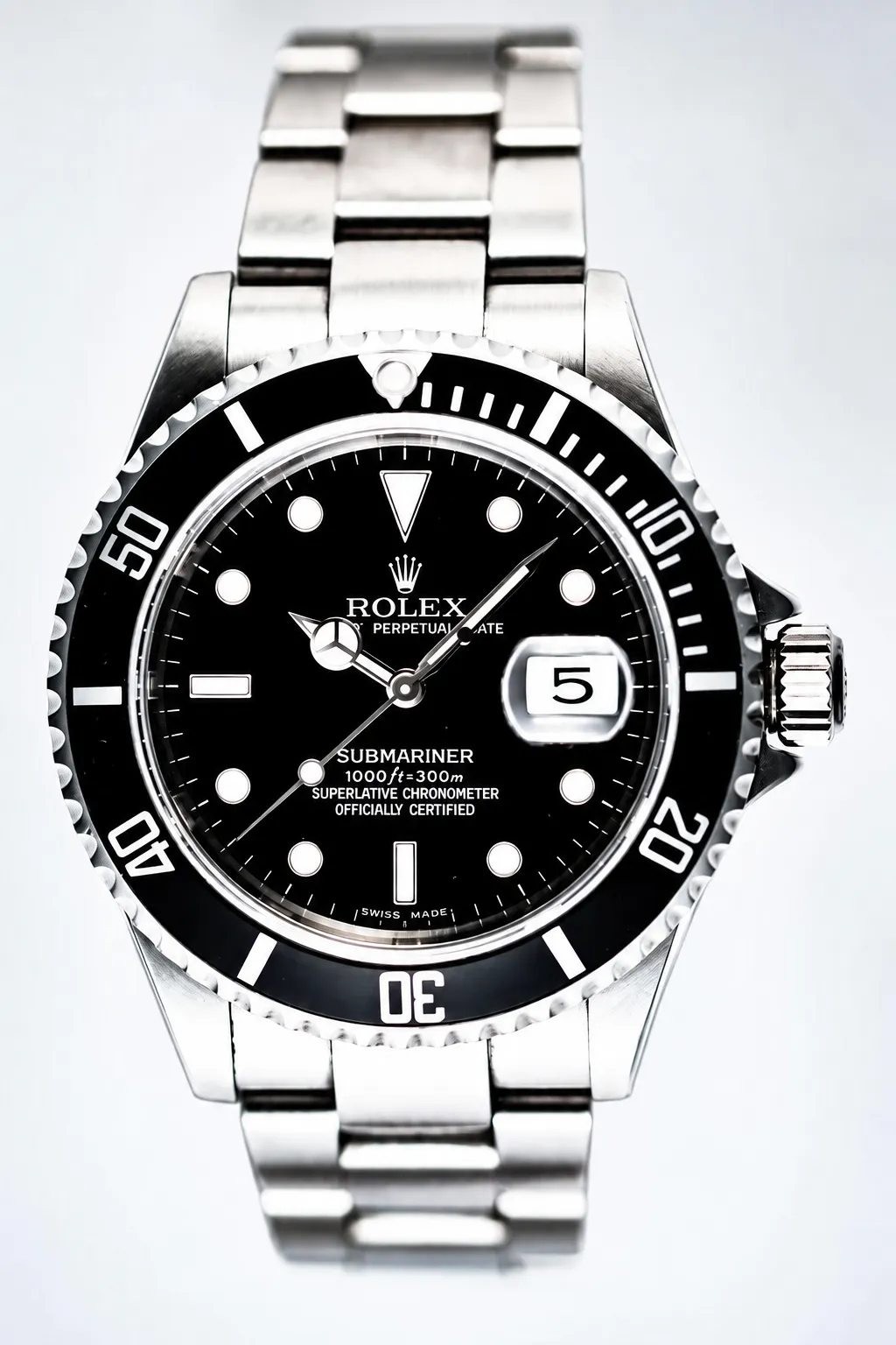 Eine Nahaufnahme einer Rolex Submariner-Armbanduhr mit schwarzem Zifferblatt, silbernen Indexen, einer drehbaren Lünette, einem Datumsfenster bei 3 Uhr und einem Edelstahlarmband, fotografiert vor weißem Hintergrund im Stil professioneller Produktfotografie für Amazon.